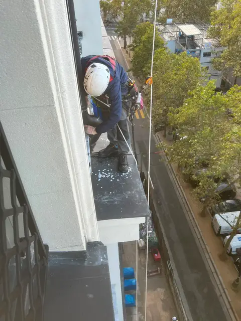 Cordiste sécurisé sur une corniche pour le nettoyage de vitres et éléments de façade